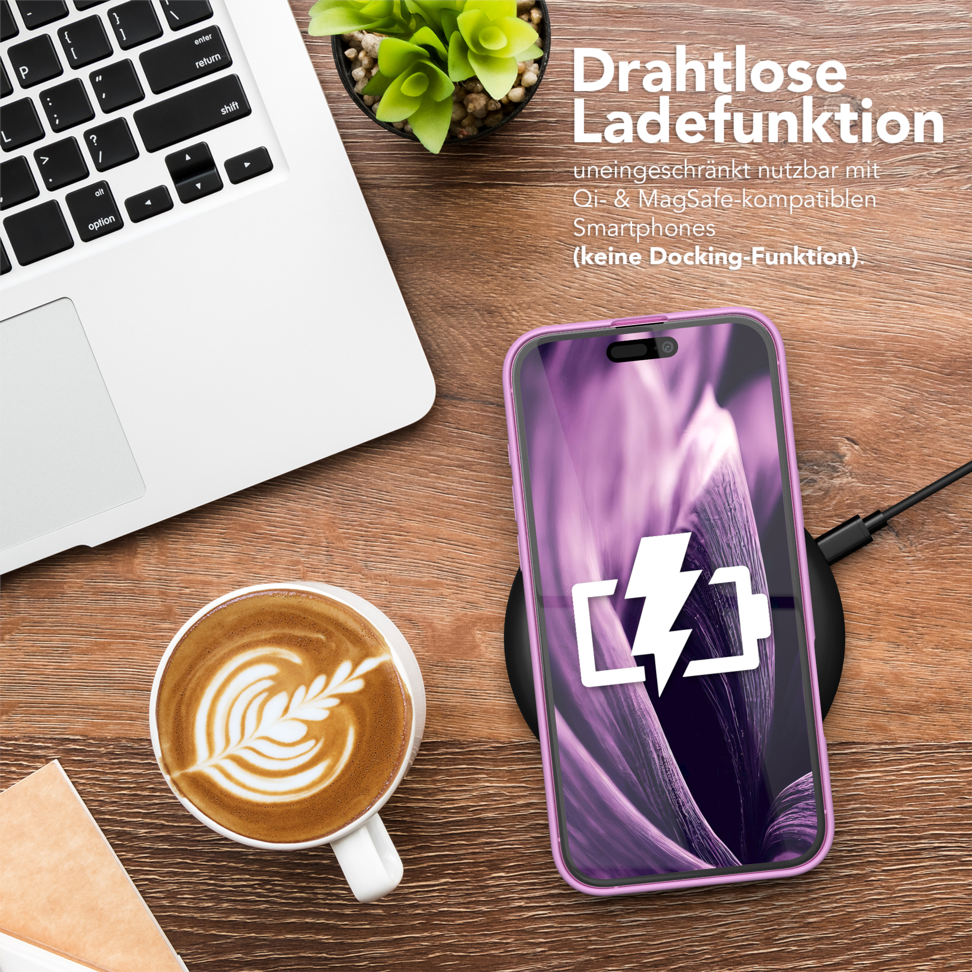Ein Telefon, das auf einem schwarzen Pad geladen wird, mit einer Kaffeetasse und einem Laptop auf einem Holztisch.