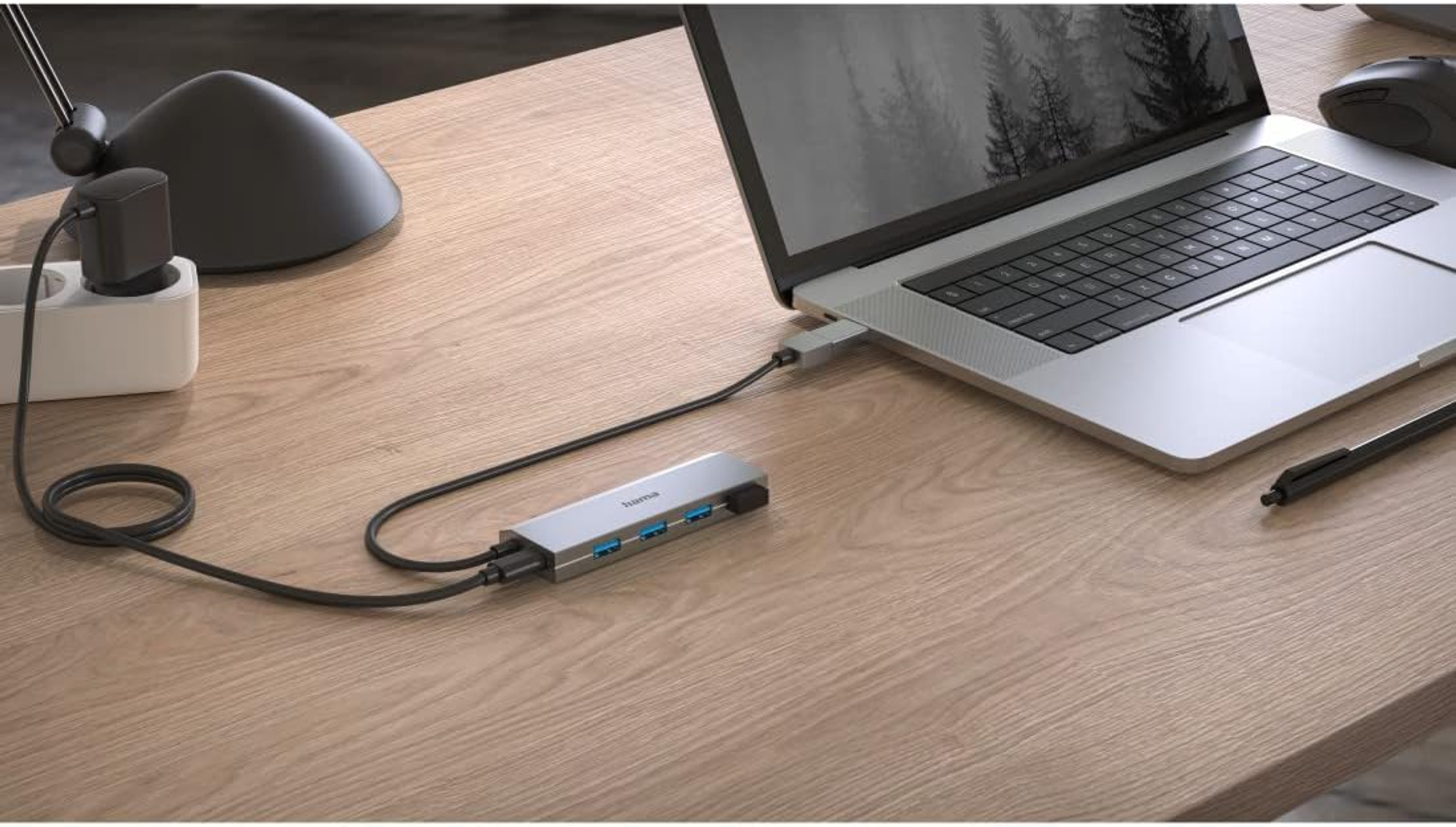 Laptop collegato a un hub USB con più porte. Cavo nero visibile.