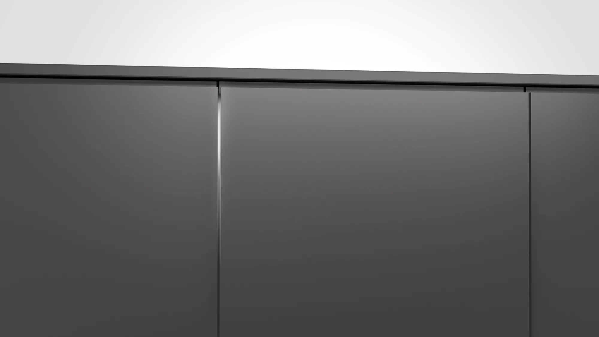 Un primo piano di un armadio grigio scuro con tre ante. C'è un muro bianco sopra.
