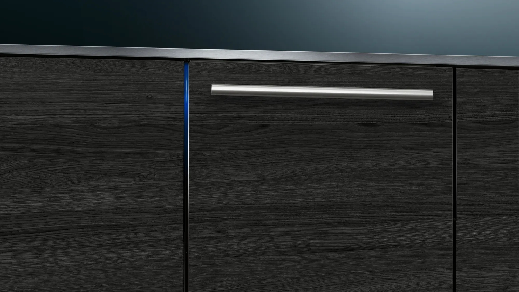 Primo piano di un mobile in legno scuro con maniglia argentata. Luce blu laterale.
