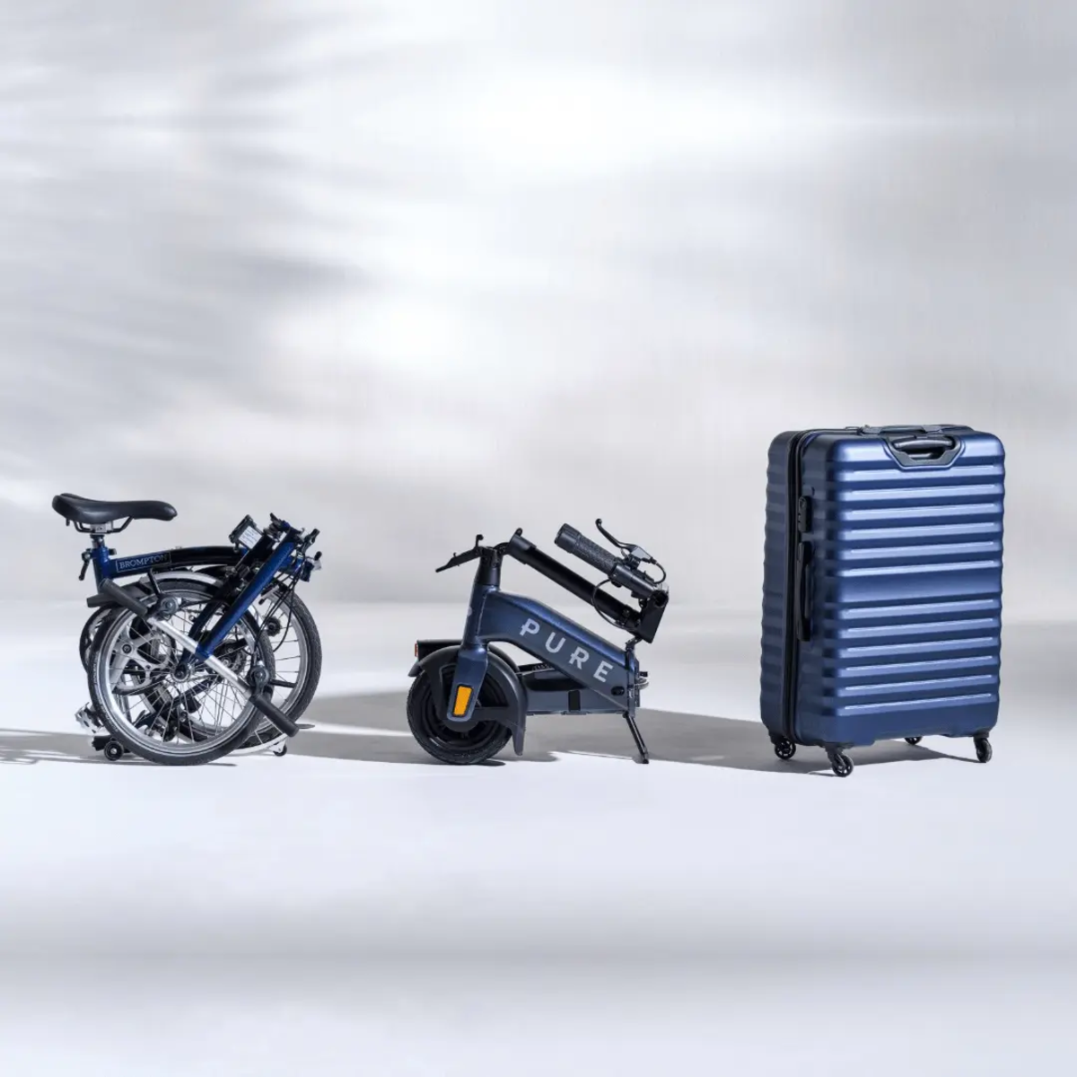 Fahrrad, E-Bike und Gepäck auf Weiß. Räder sind blau, Gepäck ist blau.