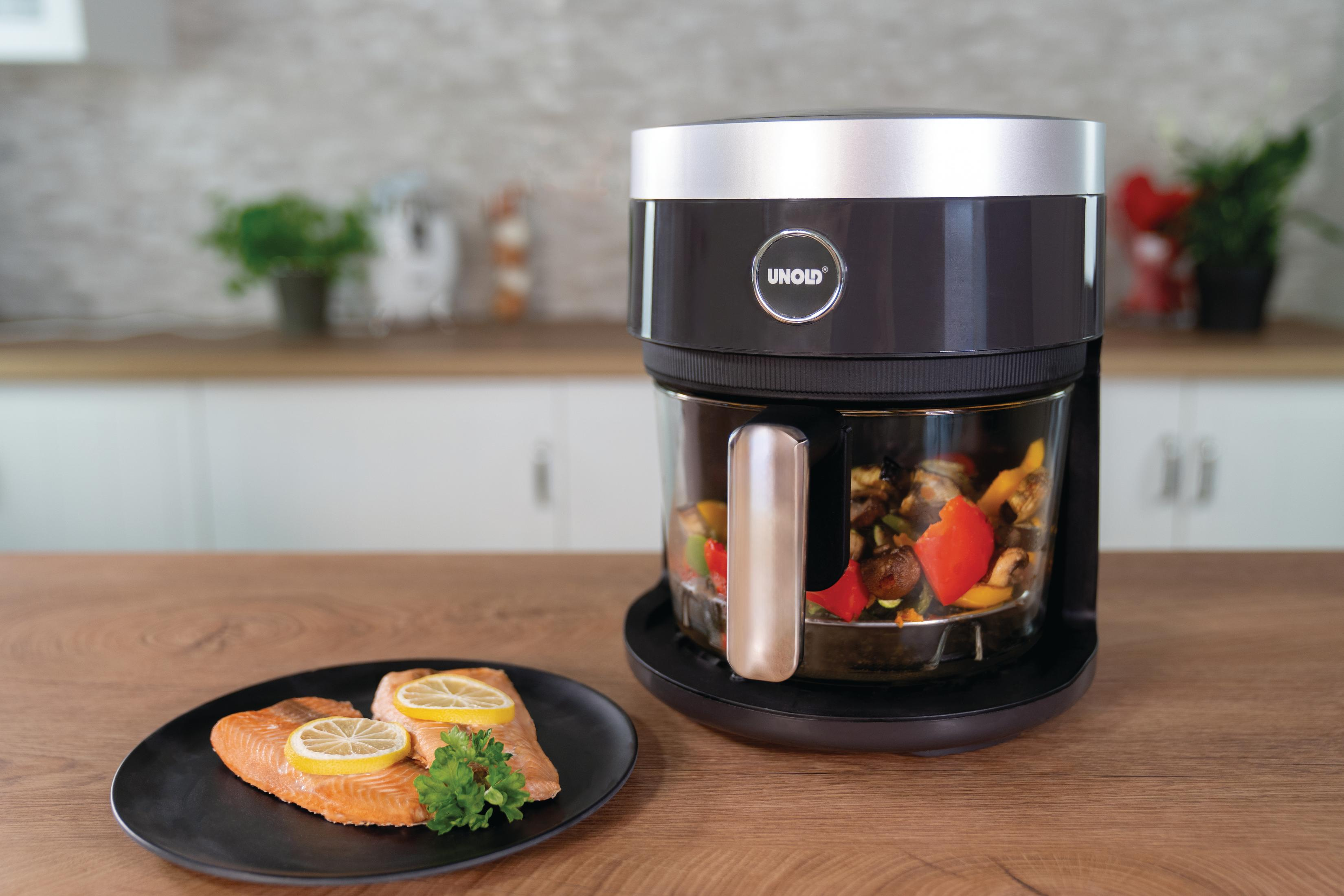 Robot kuchenny z warzywami. Łosoś na talerzu z plasterkami cytryny. Drewniany stół w tle.