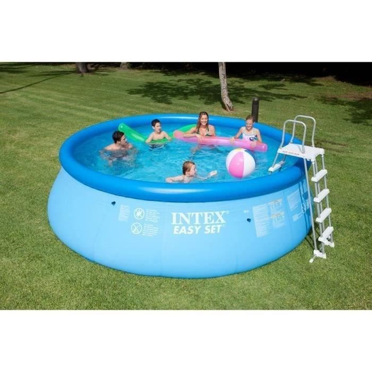 Eine Gruppe von Menschen in einem blauen aufblasbaren Pool mit Spielzeug, die auf einer grünen Wiese schwimmen und spielen.