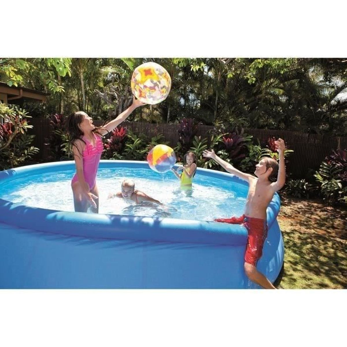 Kinder spielen in einem blauen Pool mit einem Strandball.