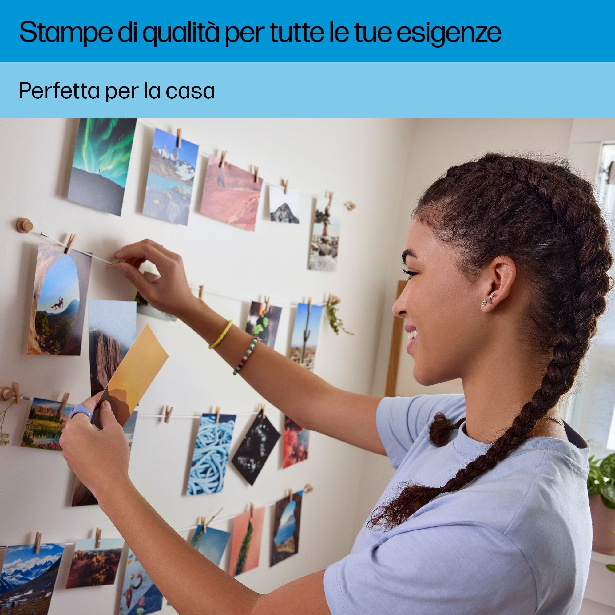Femme accrochant des photos. Mur avec photos et cordes. Femme souriante, longue tresse.