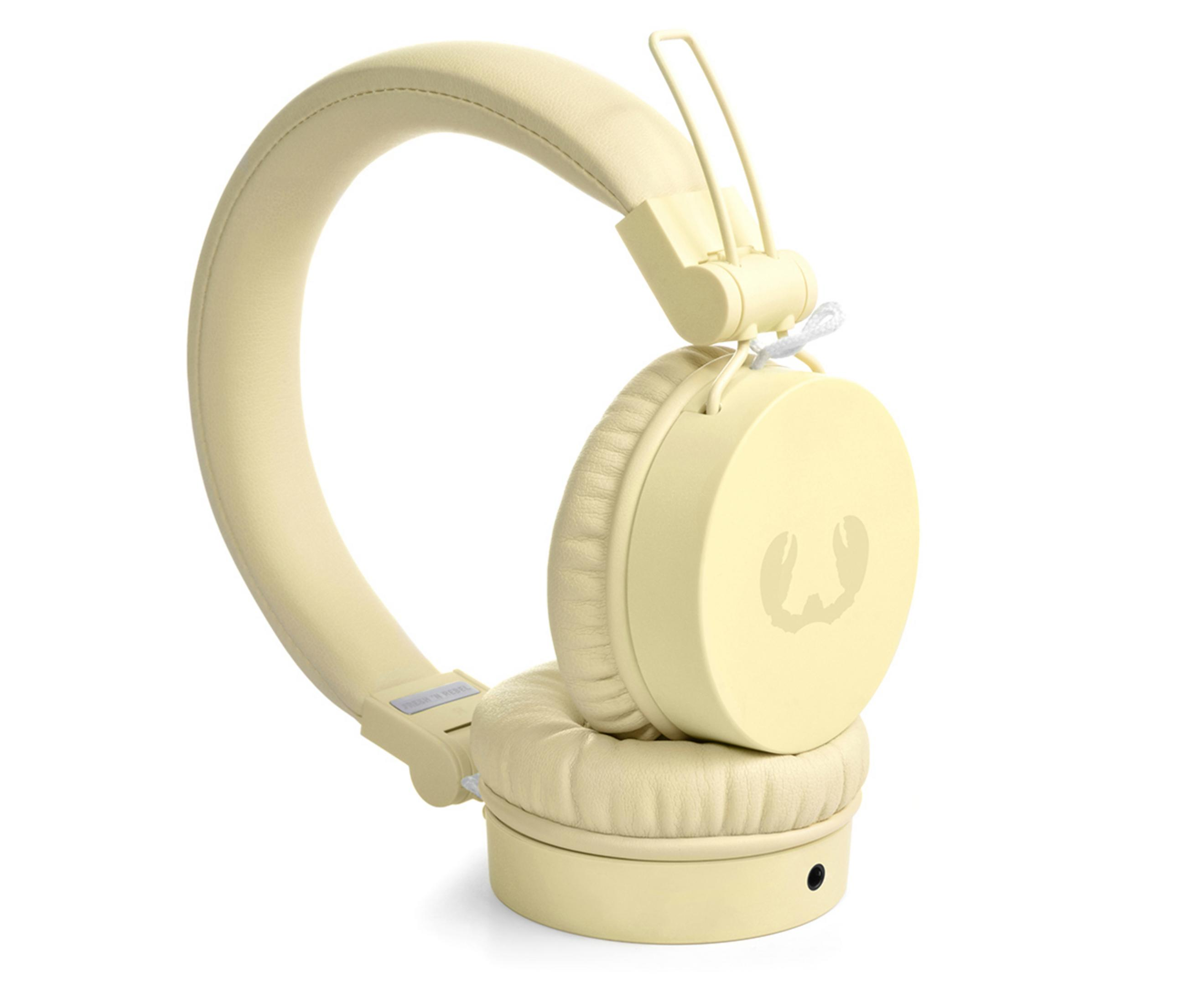 Kremowe słuchawki, widok z boku. Słuchawki mają okrągłą muszlę i pałąk.