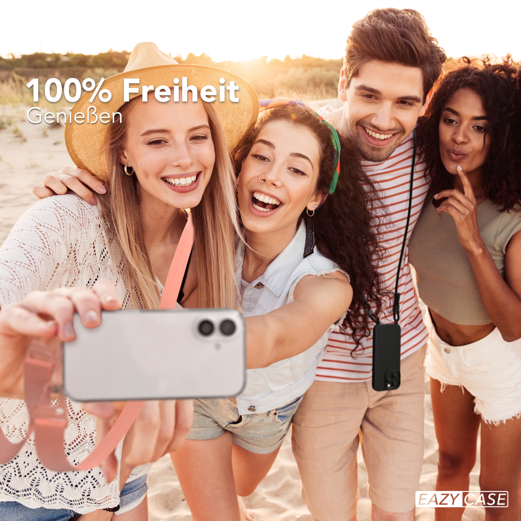 Vier lächelnde Personen machen ein Selfie mit einem Telefon am Strand.