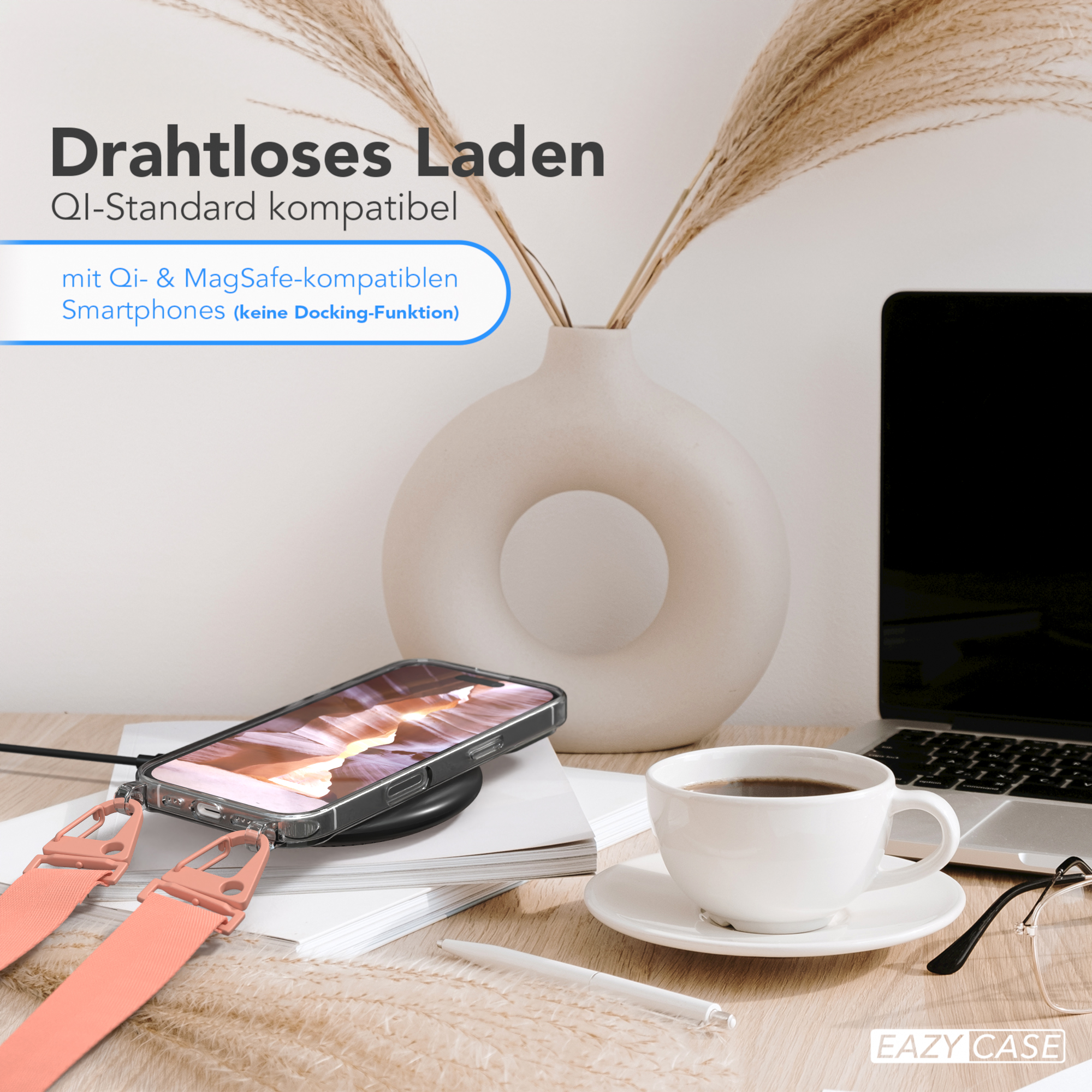 Ein Telefon liegt auf einem kabellosen Ladegerät. Kaffee, Brille und Laptop auf dem Tisch.