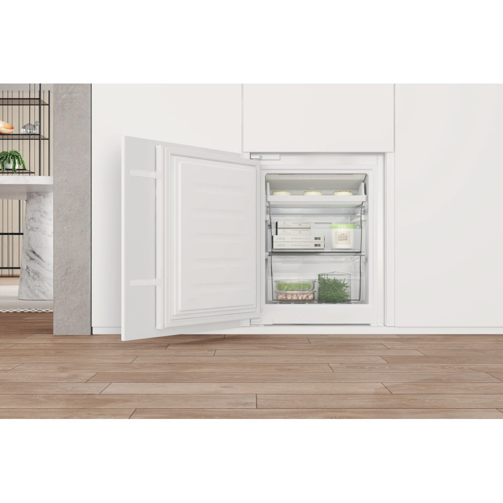 Refrigerador blanco con la puerta abierta. Dentro, hay estantes con alimentos.