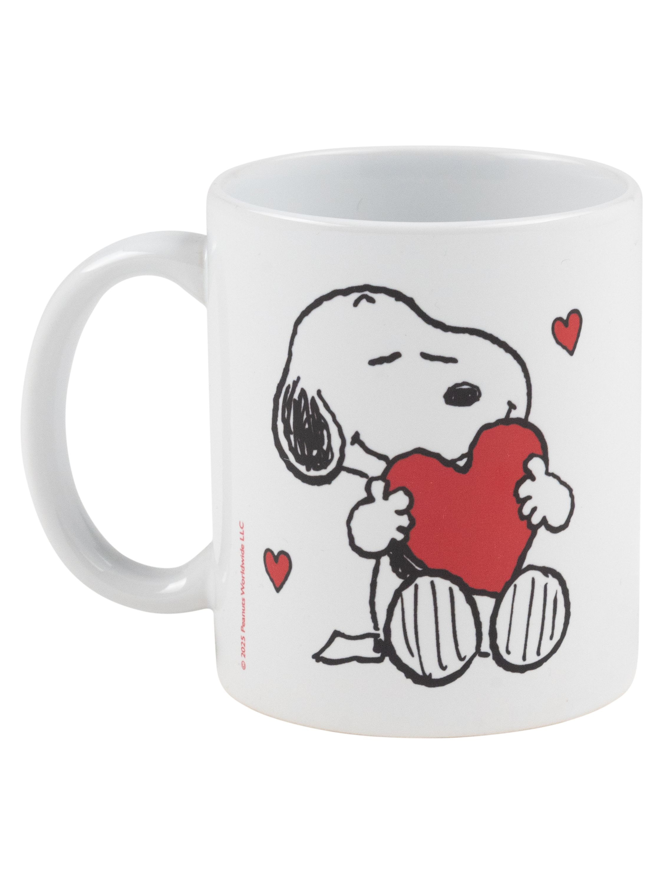 Weiße Tasse mit Snoopy und rotem Herz. Snoopy umarmt das Herz. Weißer Hintergrund.
