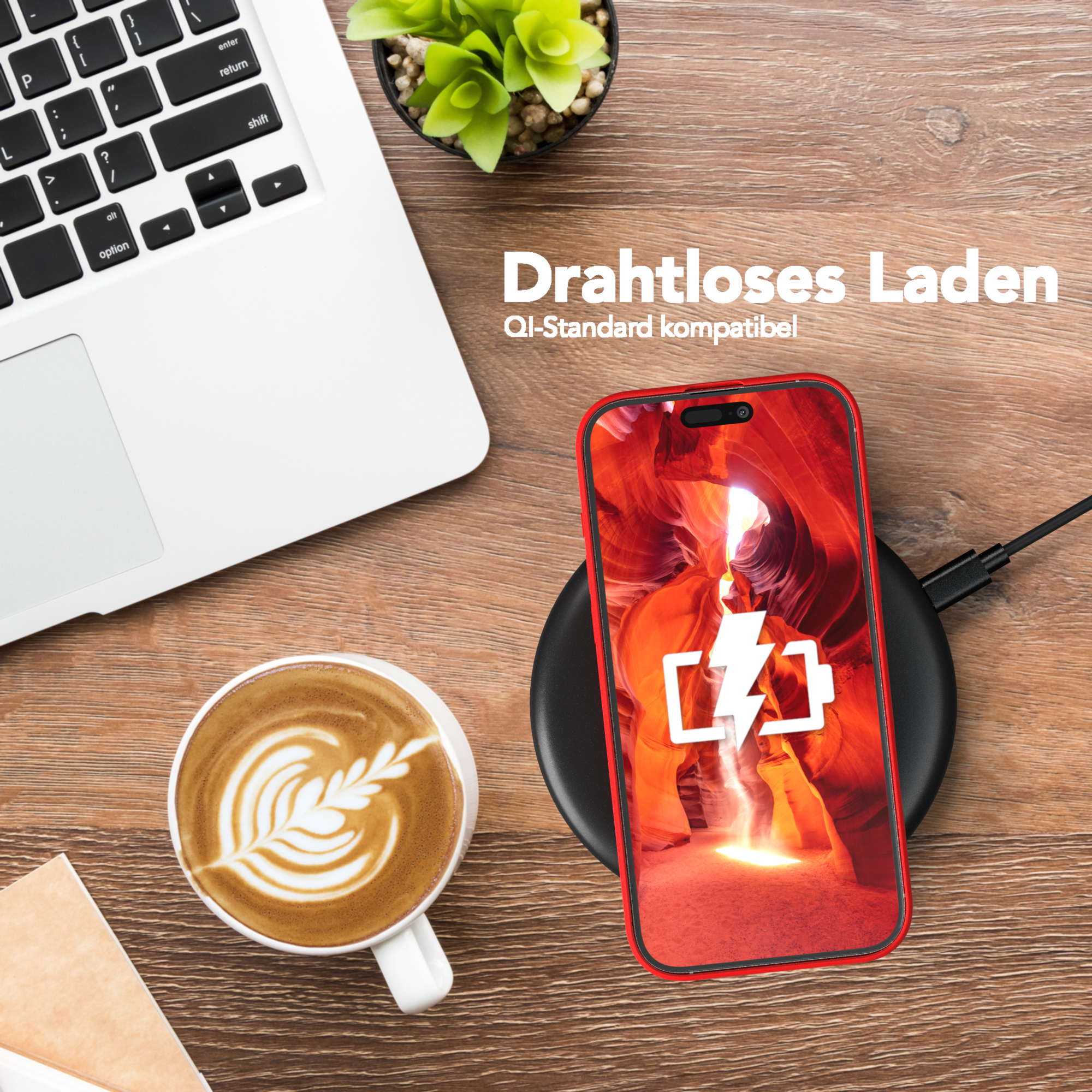 Telefon lädt kabellos. Laptop, Kaffeetasse und Pflanze auf einem Holztisch.