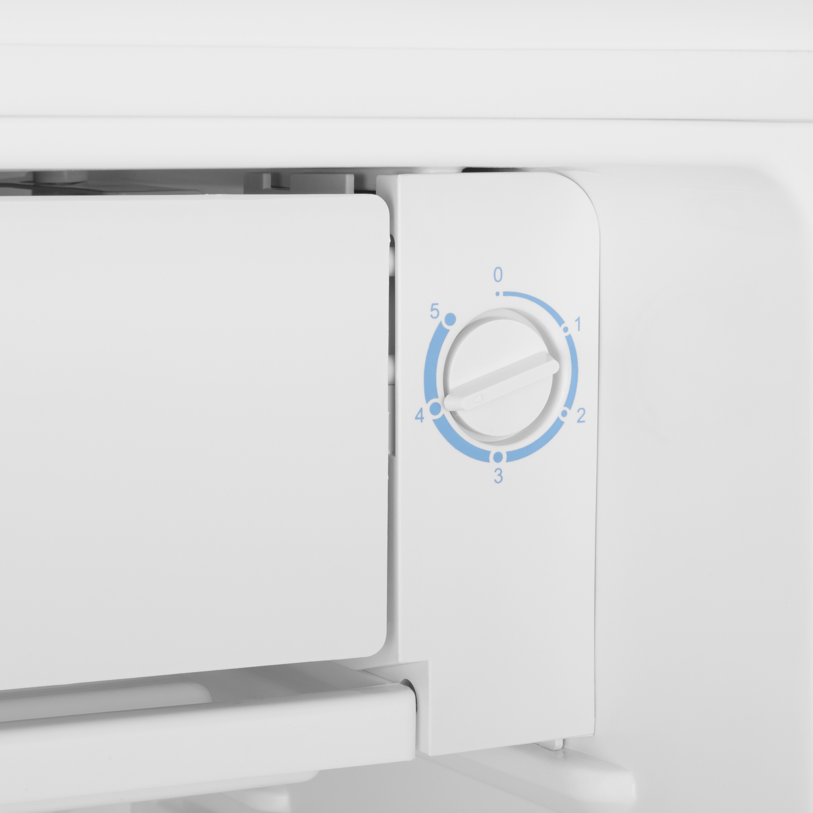 Primer plano del interior de un refrigerador, mostrando el dial de control de temperatura con números.
