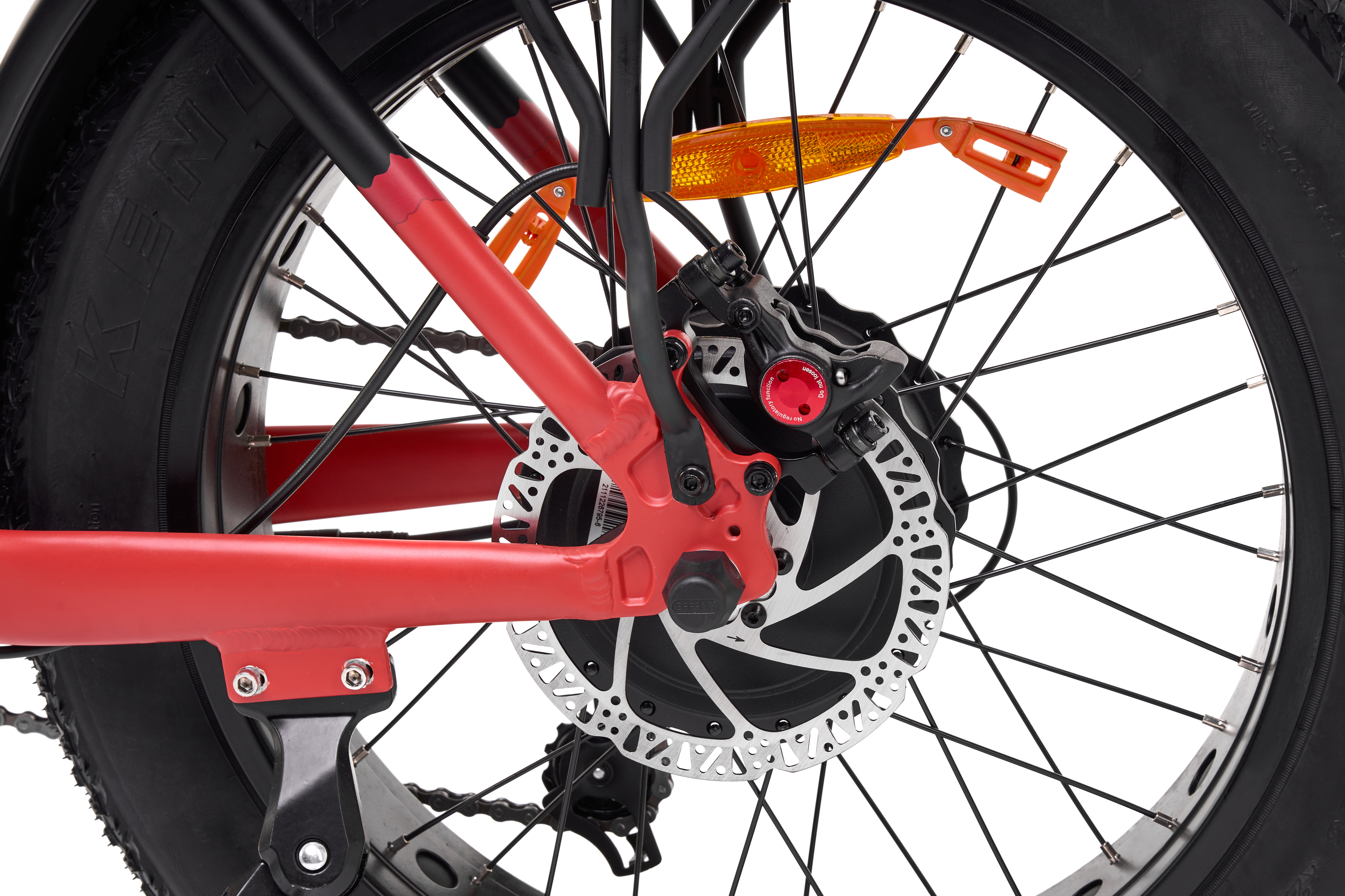 Un primo piano di una ruota di bicicletta rossa. La ruota ha un freno a disco, uno pneumatico nero e un telaio rosso.