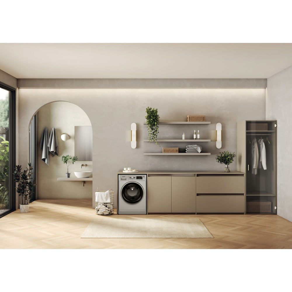 Interno lavanderia. Lavatrice, mensole con decorazioni, specchio e armadio presenti.