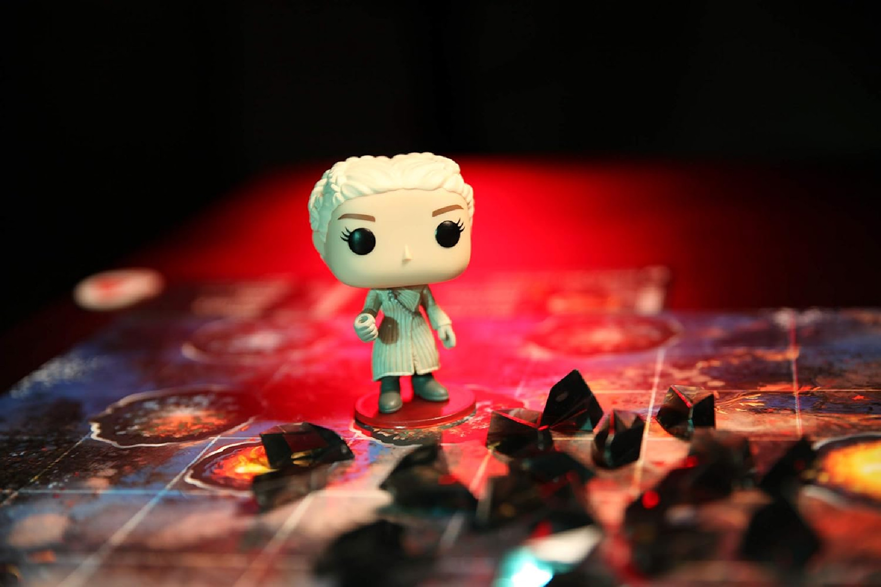 Eine Funko Pop Figur einer Frau auf einem Spielbrett mit roter und schwarzer Beleuchtung.