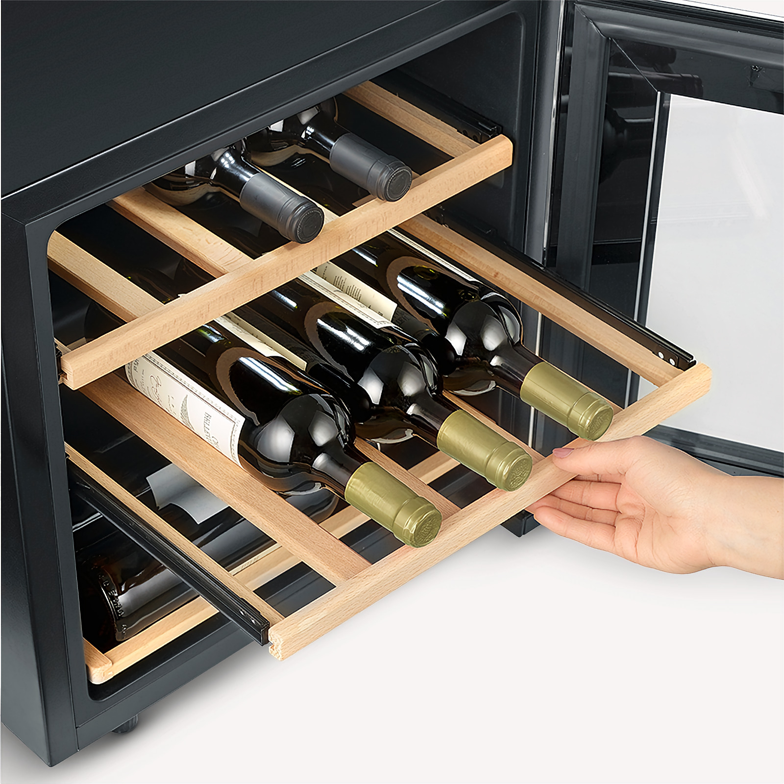 Una mano che estrae un ripiano in legno pieno di bottiglie di vino. Il frigorifero è nero con una porta a vetro.