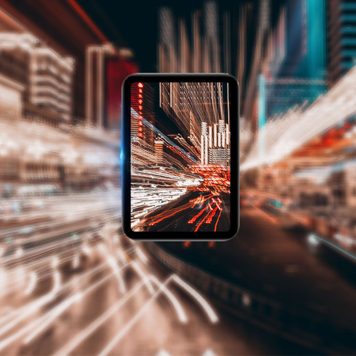 Un tablet mostra una scena urbana sfocata di notte. Anche lo sfondo è sfocato, con scie di luce.