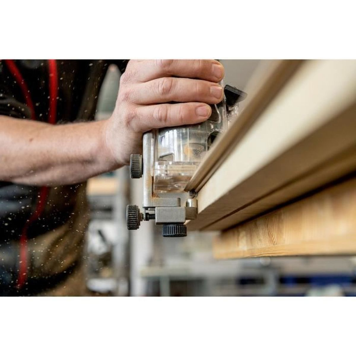 Person bearbeitet Holz mit einem Router. Der Router schneidet das Holz. Nahaufnahme.