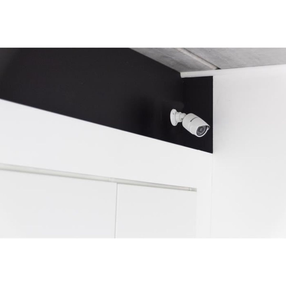 Una telecamera di sicurezza bianca montata su una parete nera, vicino a un soffitto bianco.