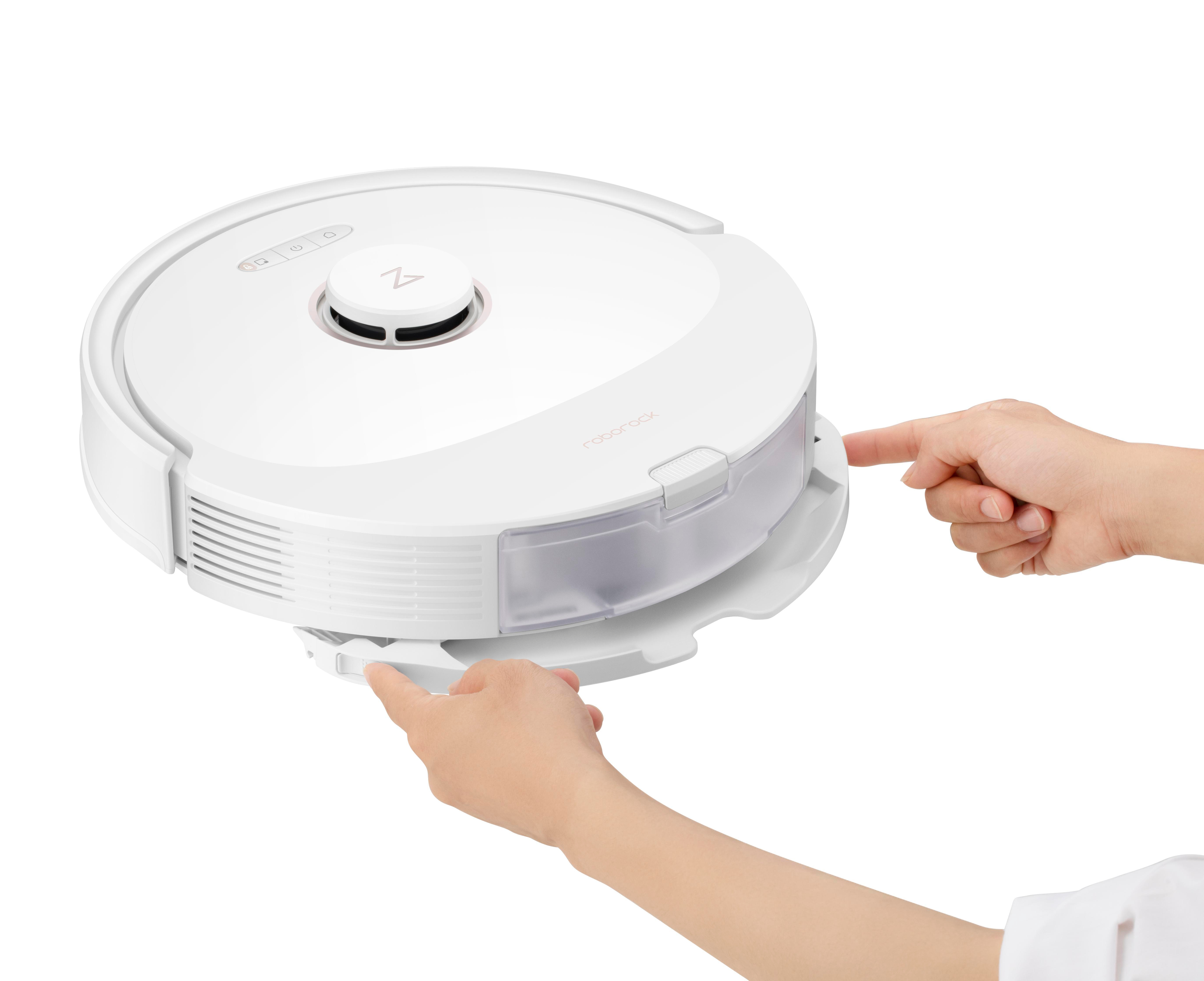 Dwie ręce otwierają pojemnik na kurz w odkurzaczu robota.