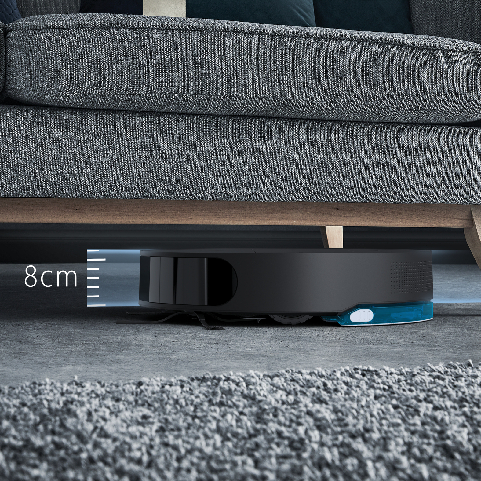 Robot sprzątający pod sofą, z widocznym pomiarem 8 cm.
