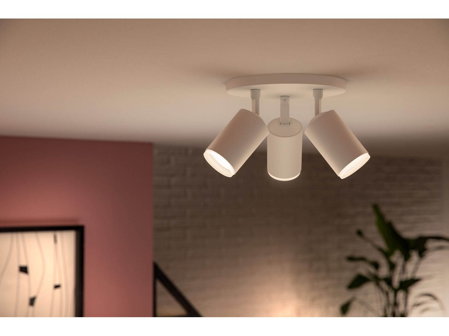 Witte plafondlampen met drie verstelbare, cilindrische spots, verlichtend in een kamer.