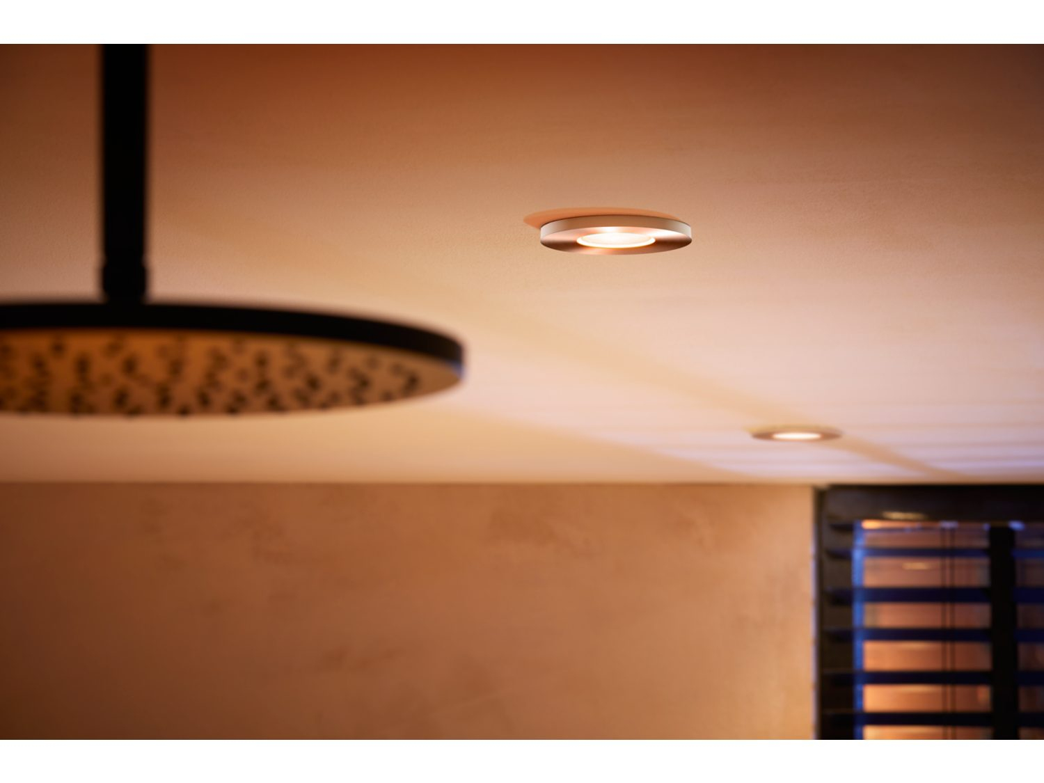 Wpuszczane oświetlenie sufitowe w łazience z prysznicem, ciepłe światło.