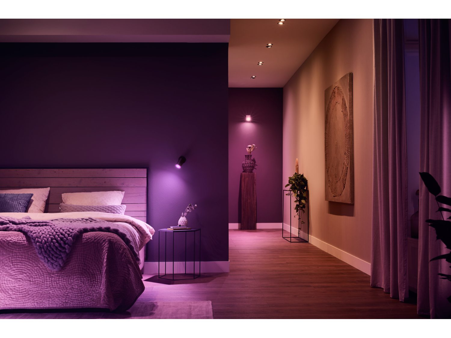 Paars verlichte slaapkamer met een bed en een gang met lichten. Modern interieur.
