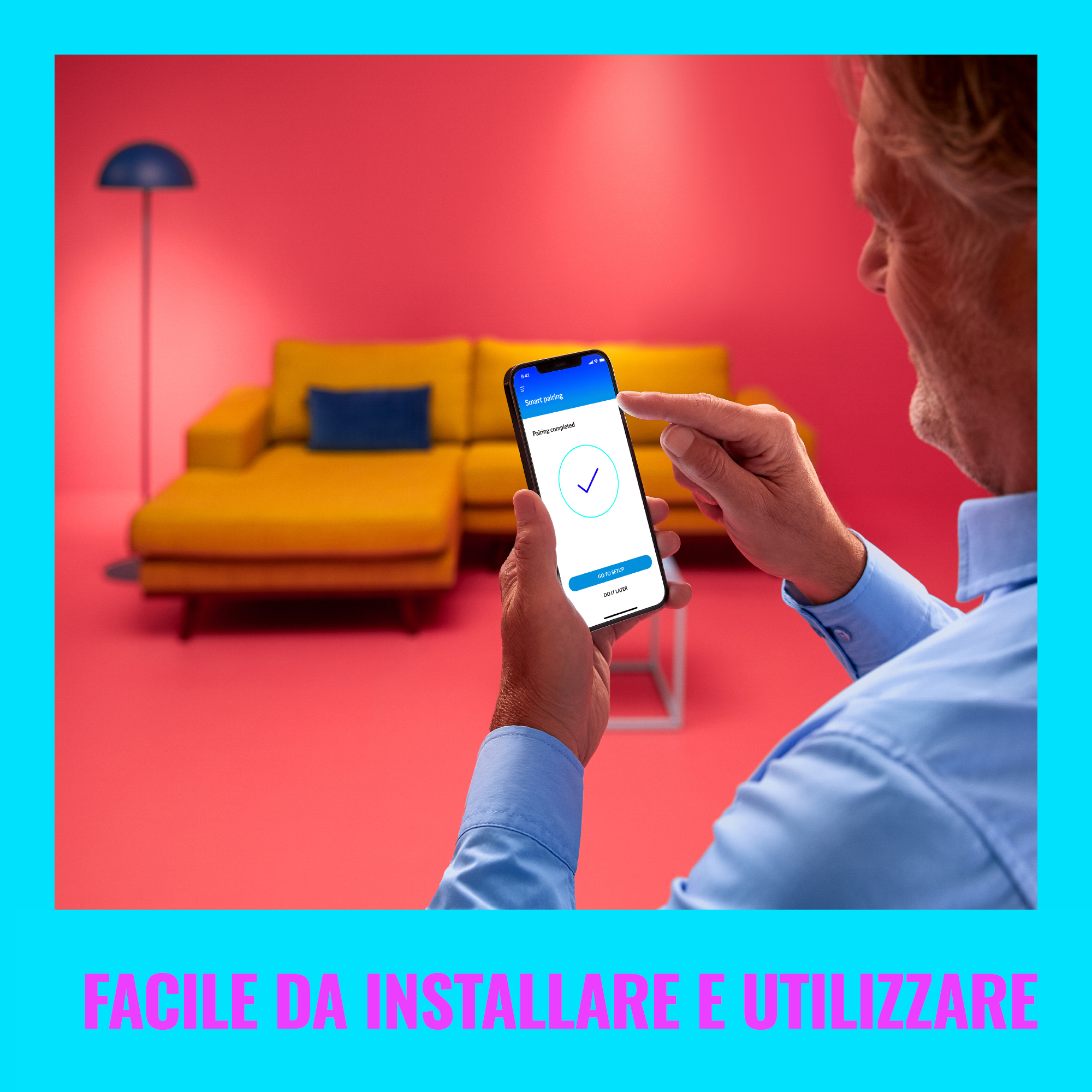 Adam, ekranda onay işareti olan bir uygulamayla telefon tutuyor. Sarı kanepe arka planı.