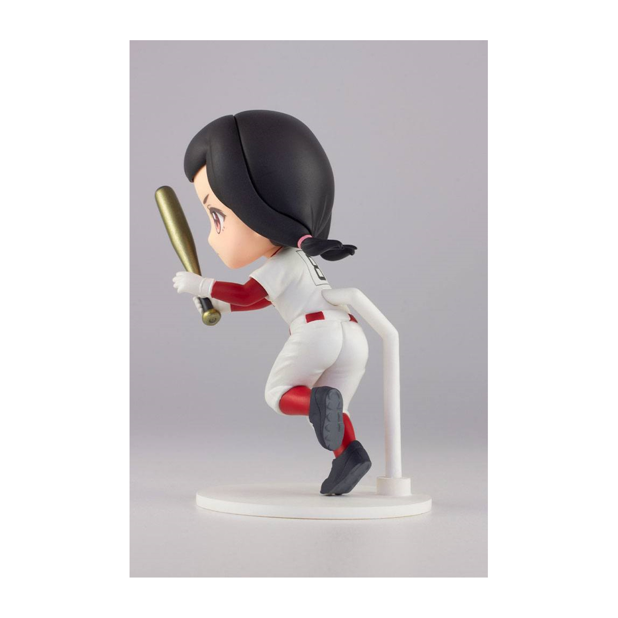 Eine Figur eines Mädchens in Baseball-Uniform, das einen Schläger hält, auf einem weißen Ständer.