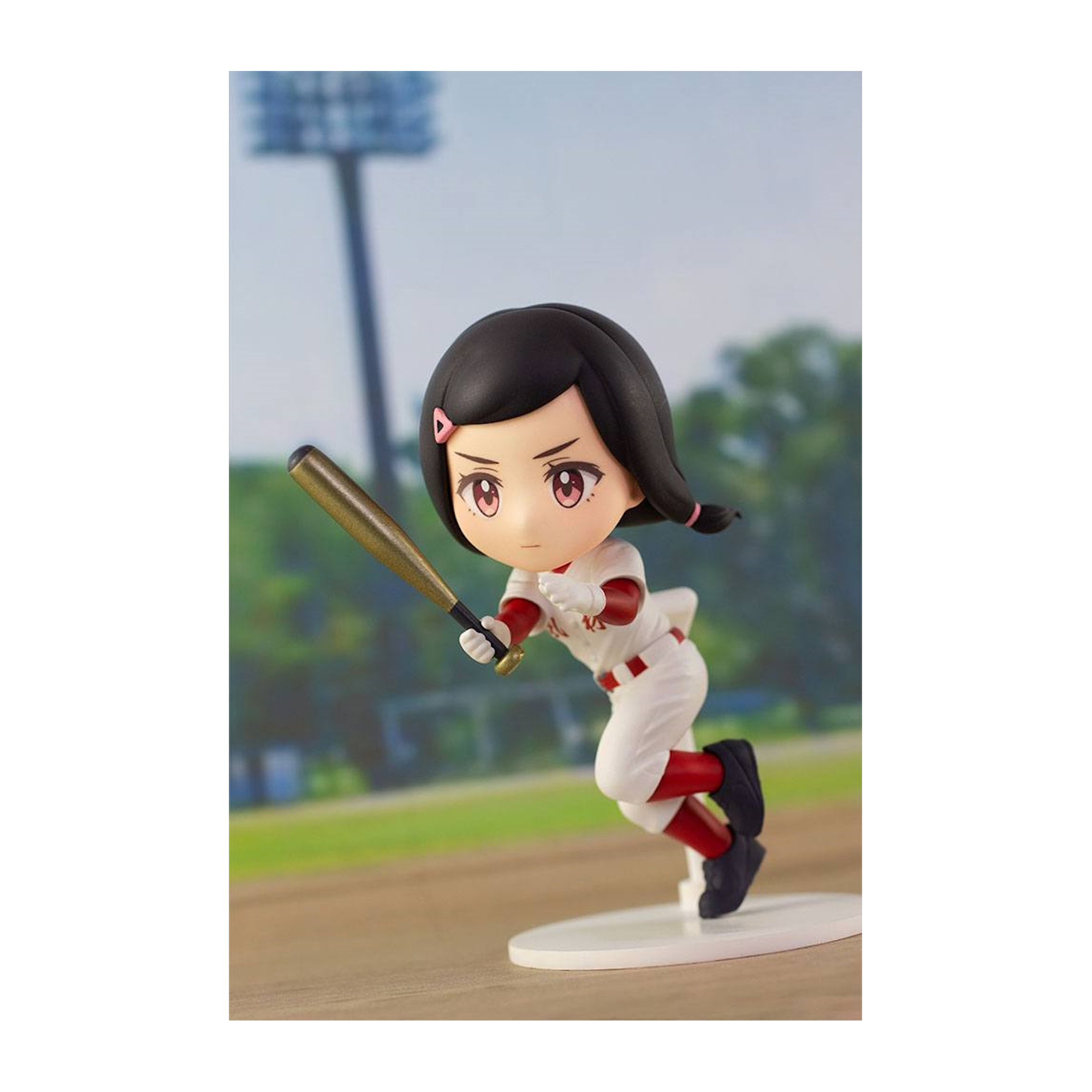 Eine Baseball-Figur eines Mädchens in Aktion mit einem Schläger. Der Hintergrund ist verschwommen.