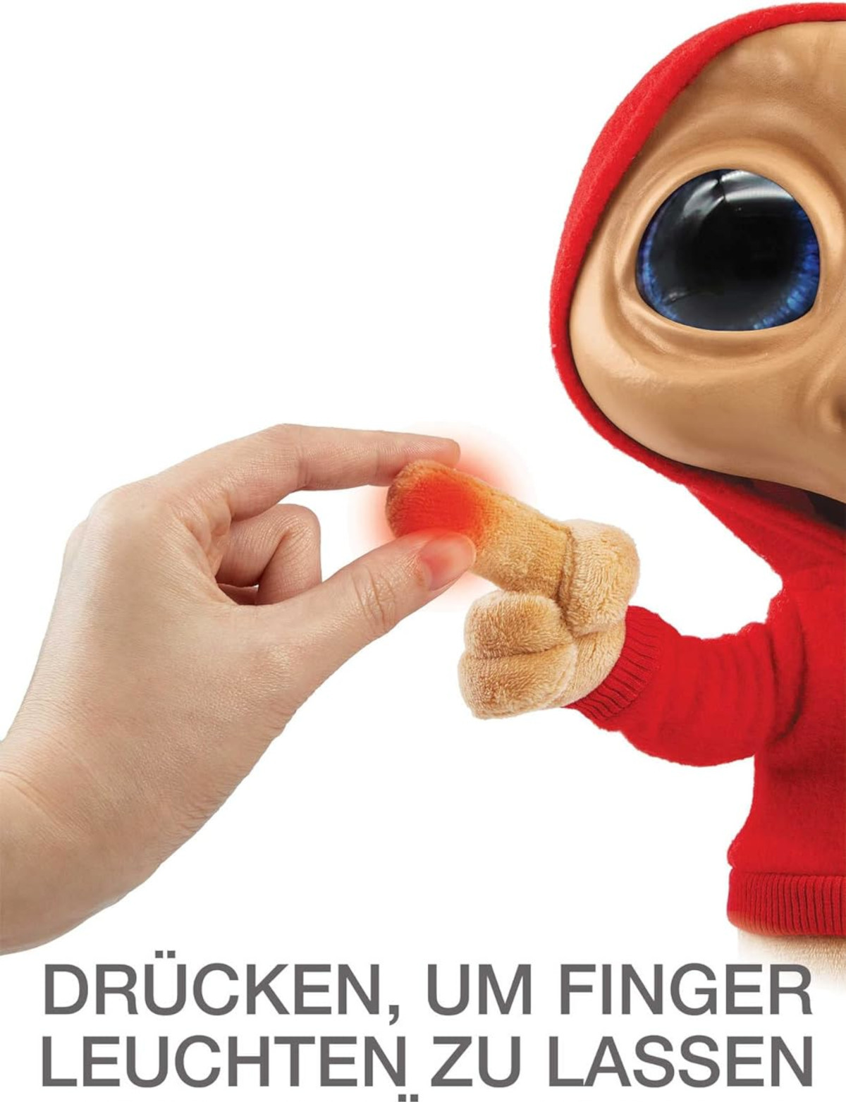 Eine Hand berührt einen Finger einer roten E.T.-Puppe, darunter ein deutscher Text.