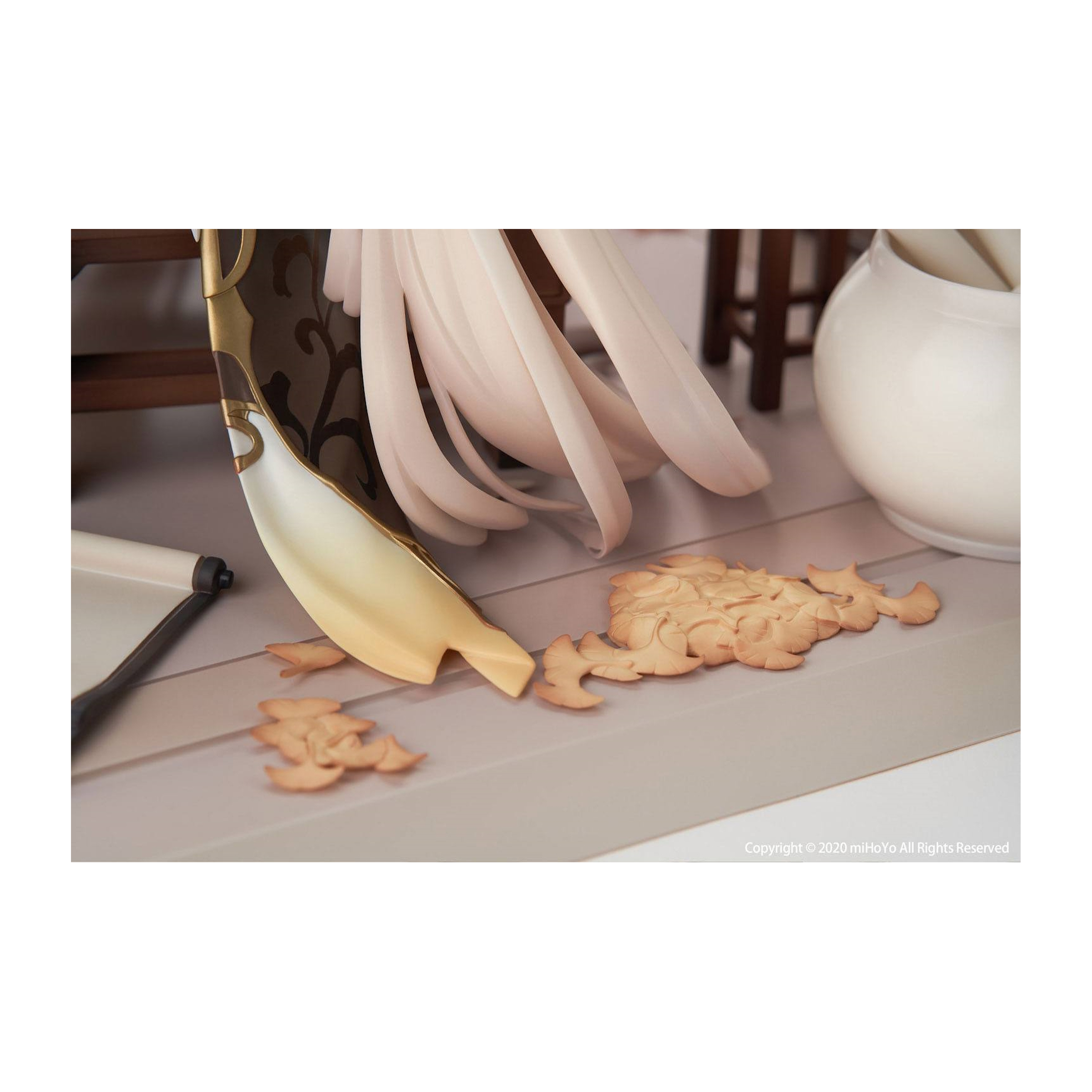 Nahaufnahme eines Tisches mit einer goldenen Sichel, Keksen und einem weißen Krug.