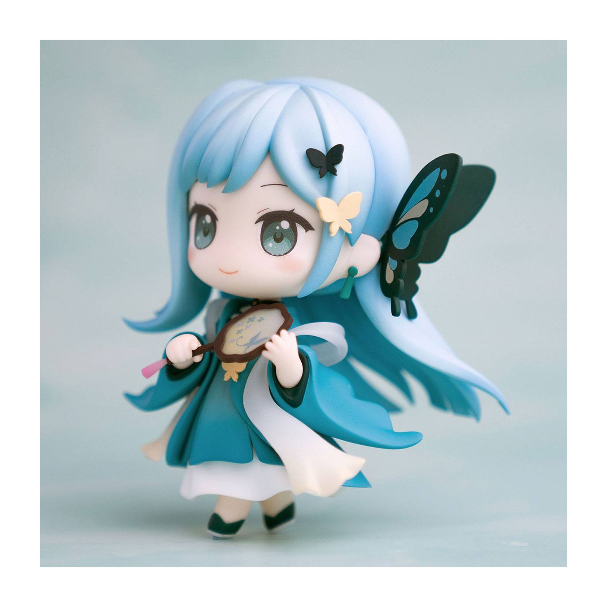 Anime-Figur eines Mädchens mit blauen Haaren und einem Fächer. Sie trägt ein türkisfarbenes Kleid.
