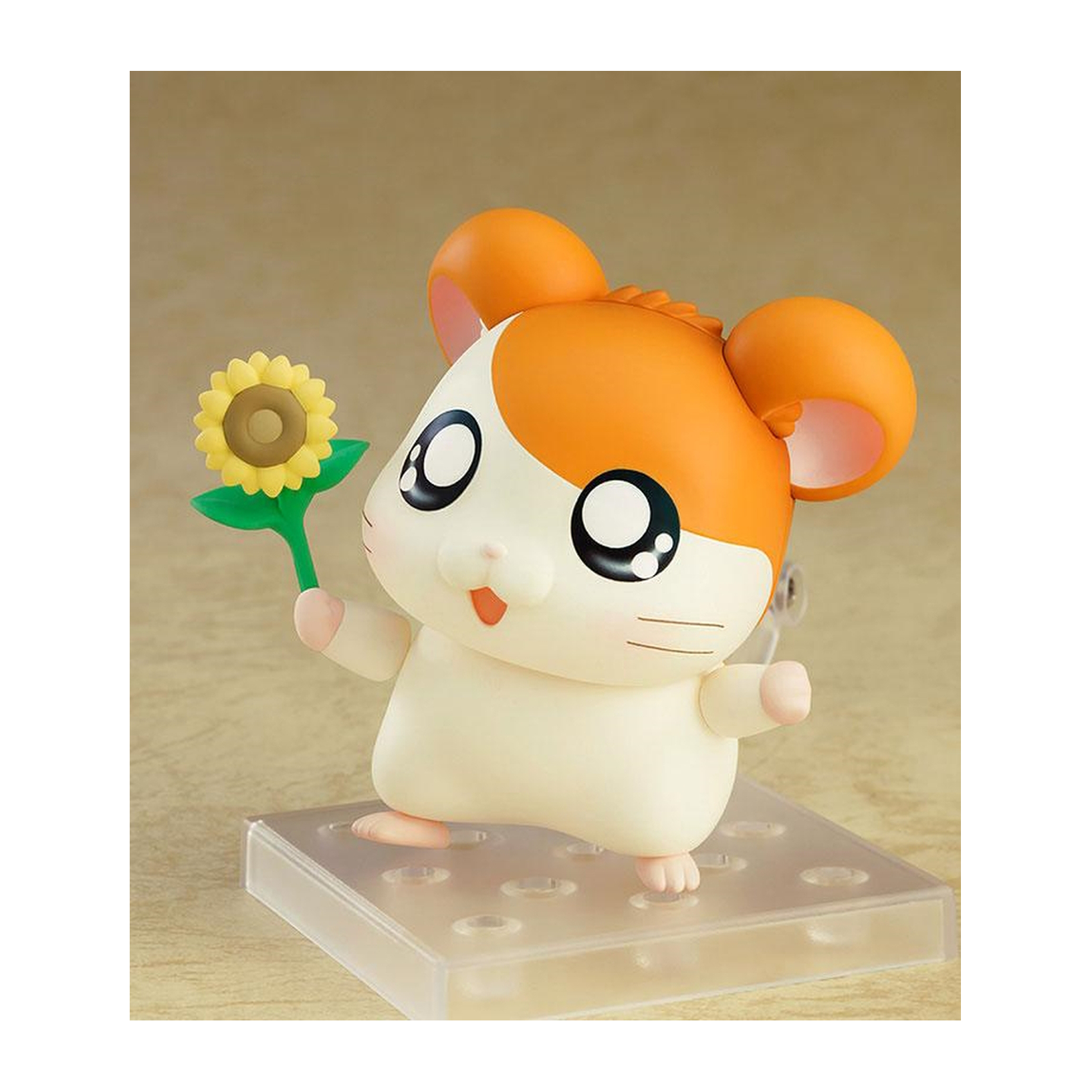 Hamsterfigur mit einer Sonnenblume. Der Hamster ist weiß und orange. Er steht auf einer transparenten Basis.
