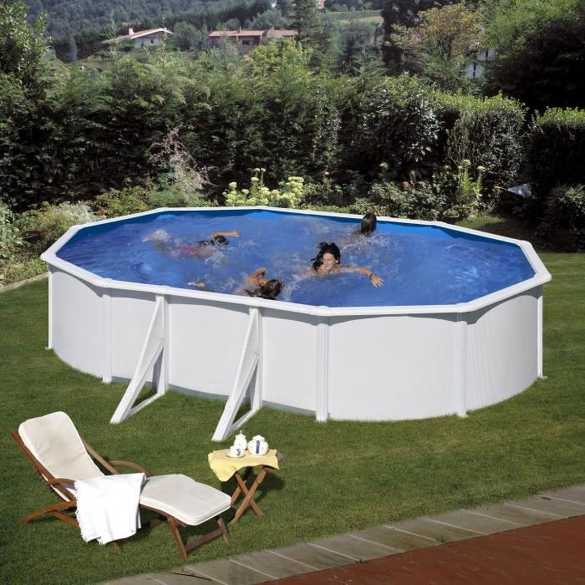 Personas nadan en una piscina azul sobre el suelo rodeada de revestimiento blanco. Hay tumbonas y una mesa cerca.