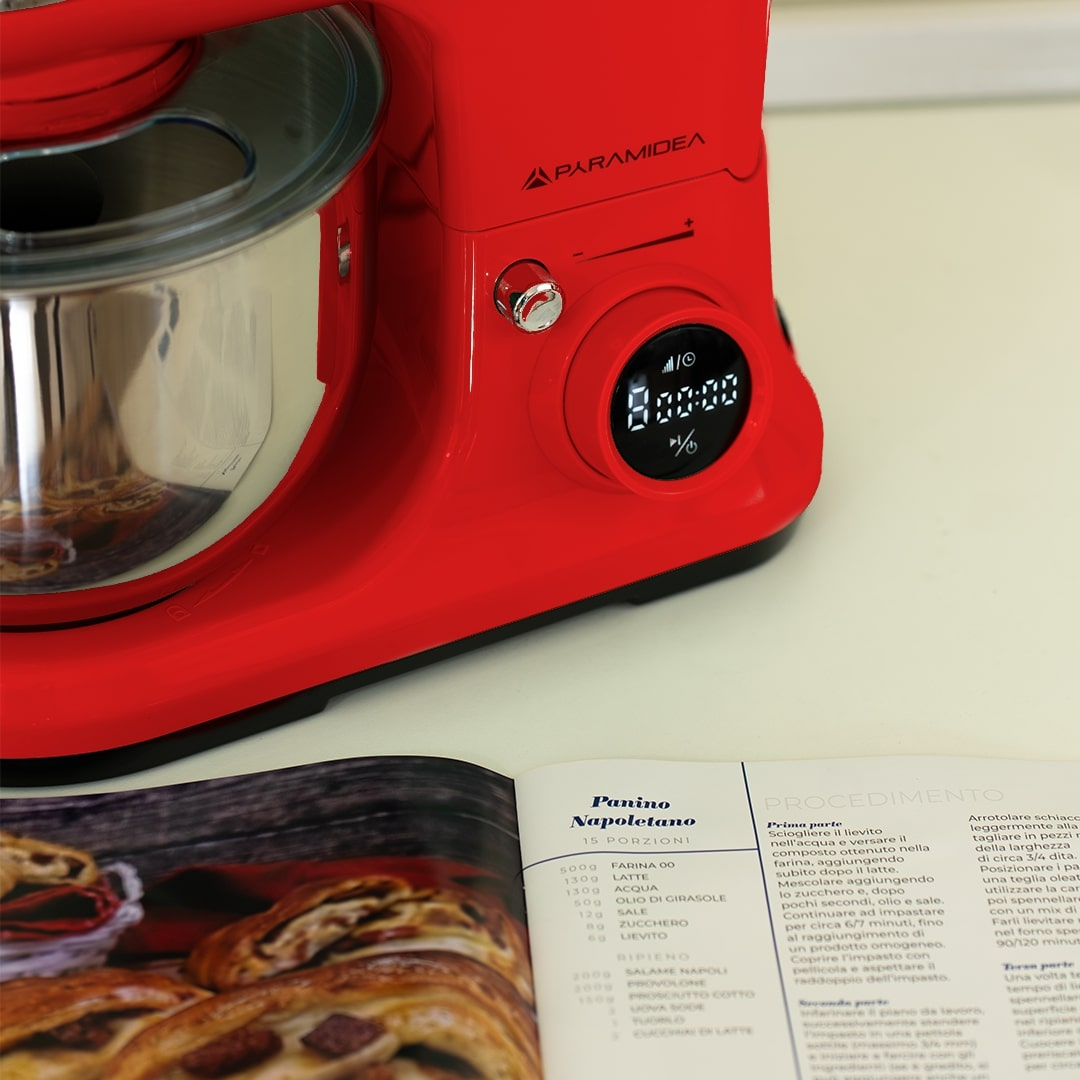 Un'impastatrice rossa con un libro di ricette intitolato "Panino Napoletano" di fronte.