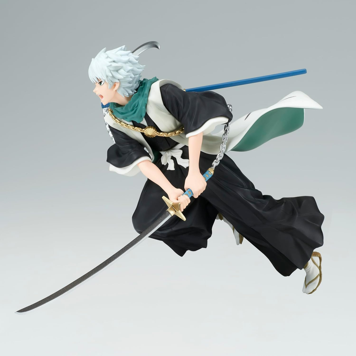 Figura de anime en pose de acción. Hombre de pelo blanco con espadas en la mano.