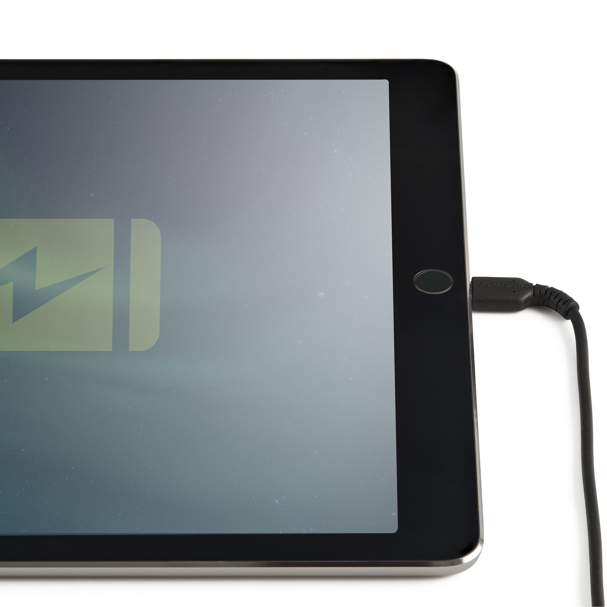 Tablet nero, cavo di ricarica collegato. Icona della batteria visibile. Sfondo bianco.