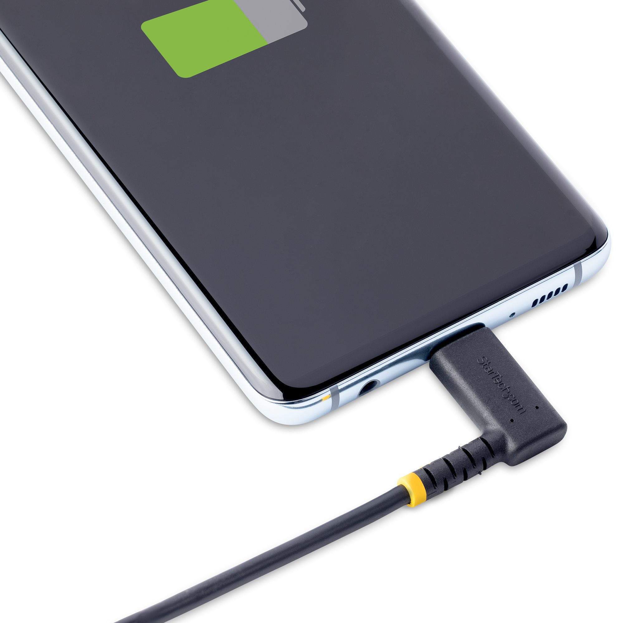 Primo piano di uno smartphone in carica. Telefono nero con cavo di ricarica con punta gialla.