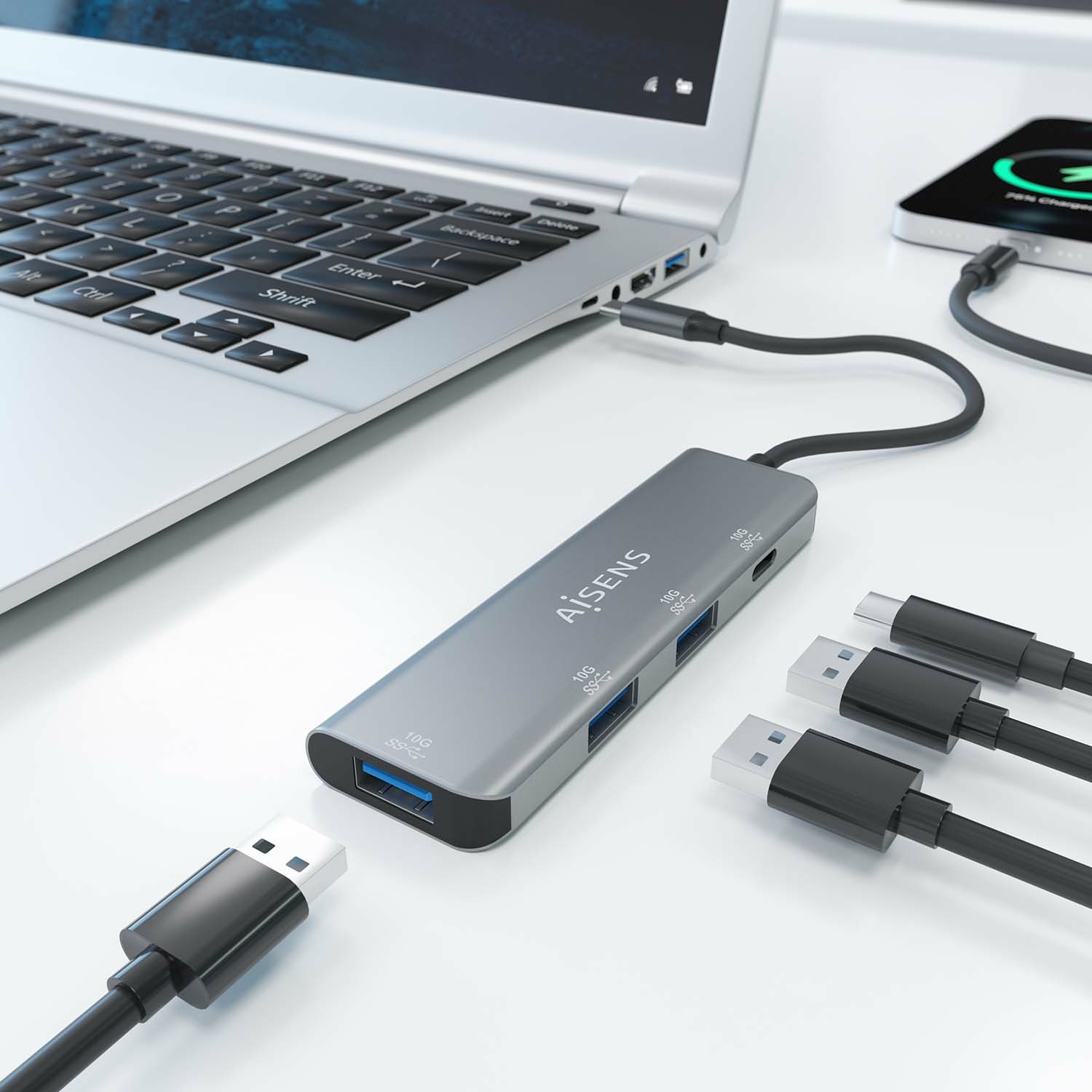 Un hub USB si collega a un laptop e ad altri dispositivi. L'hub è grigio e ha il marchio Aisens.