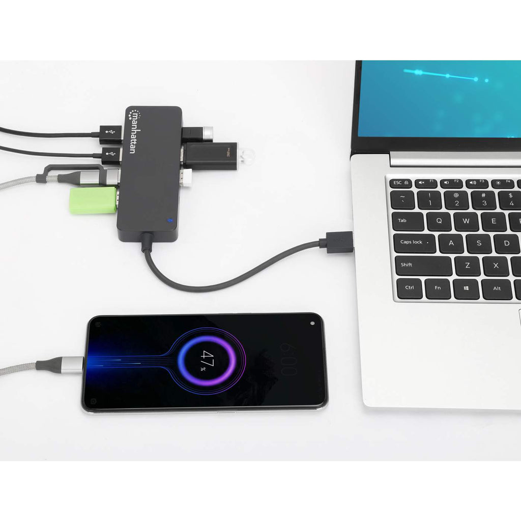 Un hub USB è collegato a un laptop e a un telefono, marchio manhattan, con percentuale di carica.