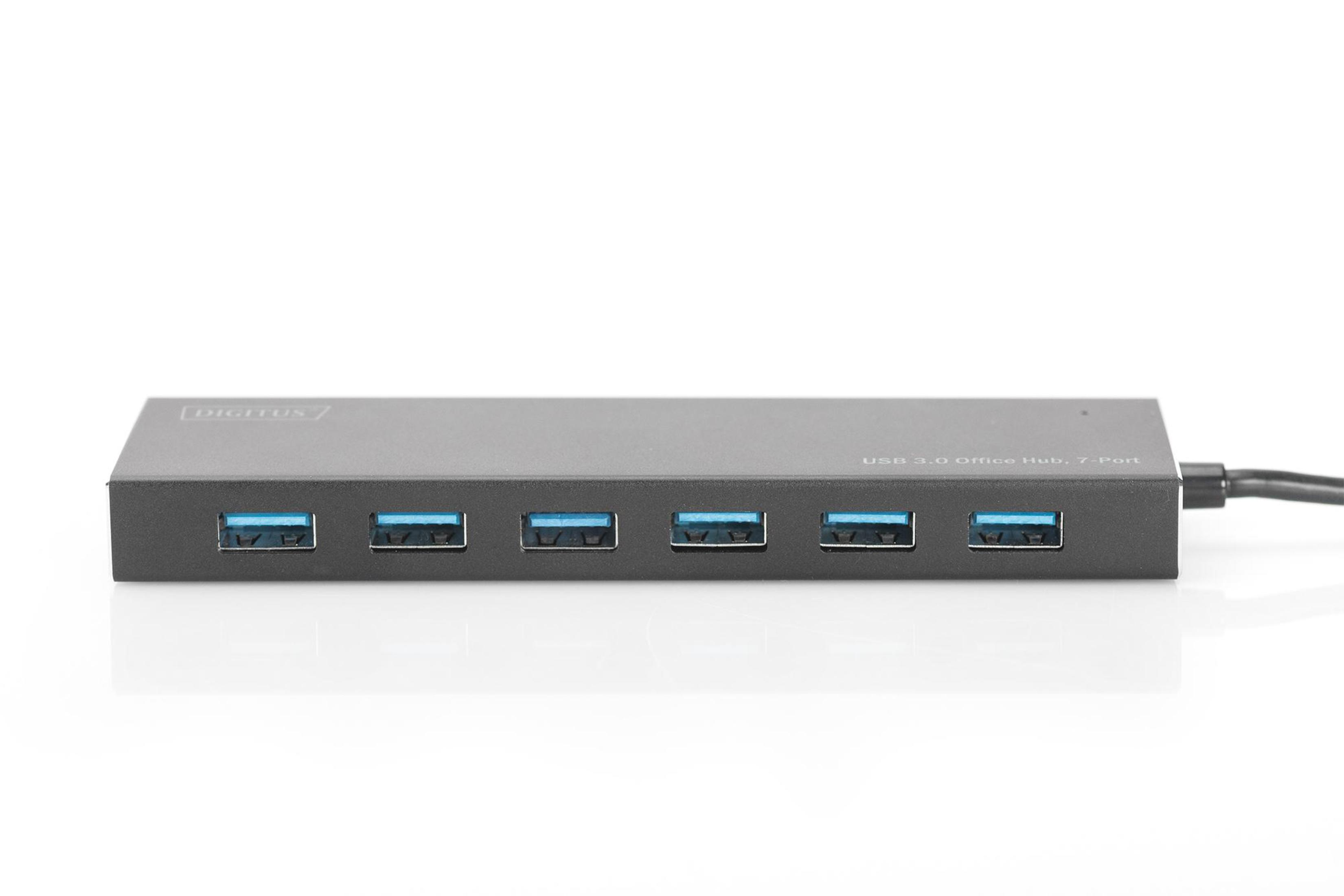7 bağlantı noktalı siyah bir USB hub. Bağlantı noktaları yatay olarak hizalanmış. Beyaz bir yüzey üzerinde.