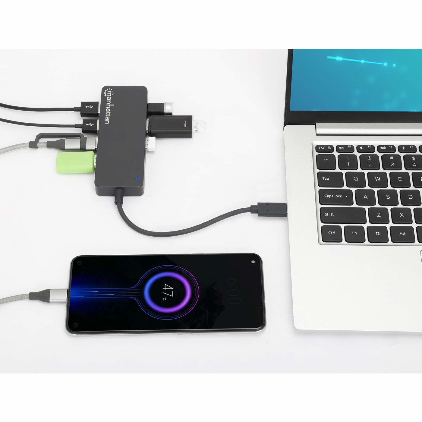 Laptop e telefono in carica tramite un hub USB. Vari dispositivi collegati.