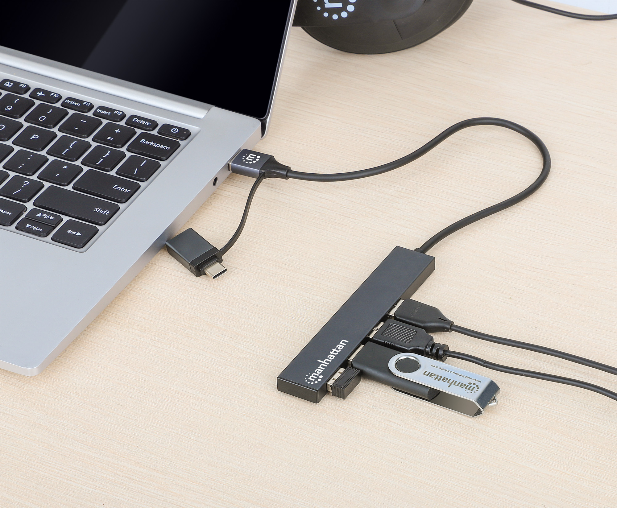 Laptop collegato a un hub USB con più porte, inclusa una chiavetta USB e un adattatore C.