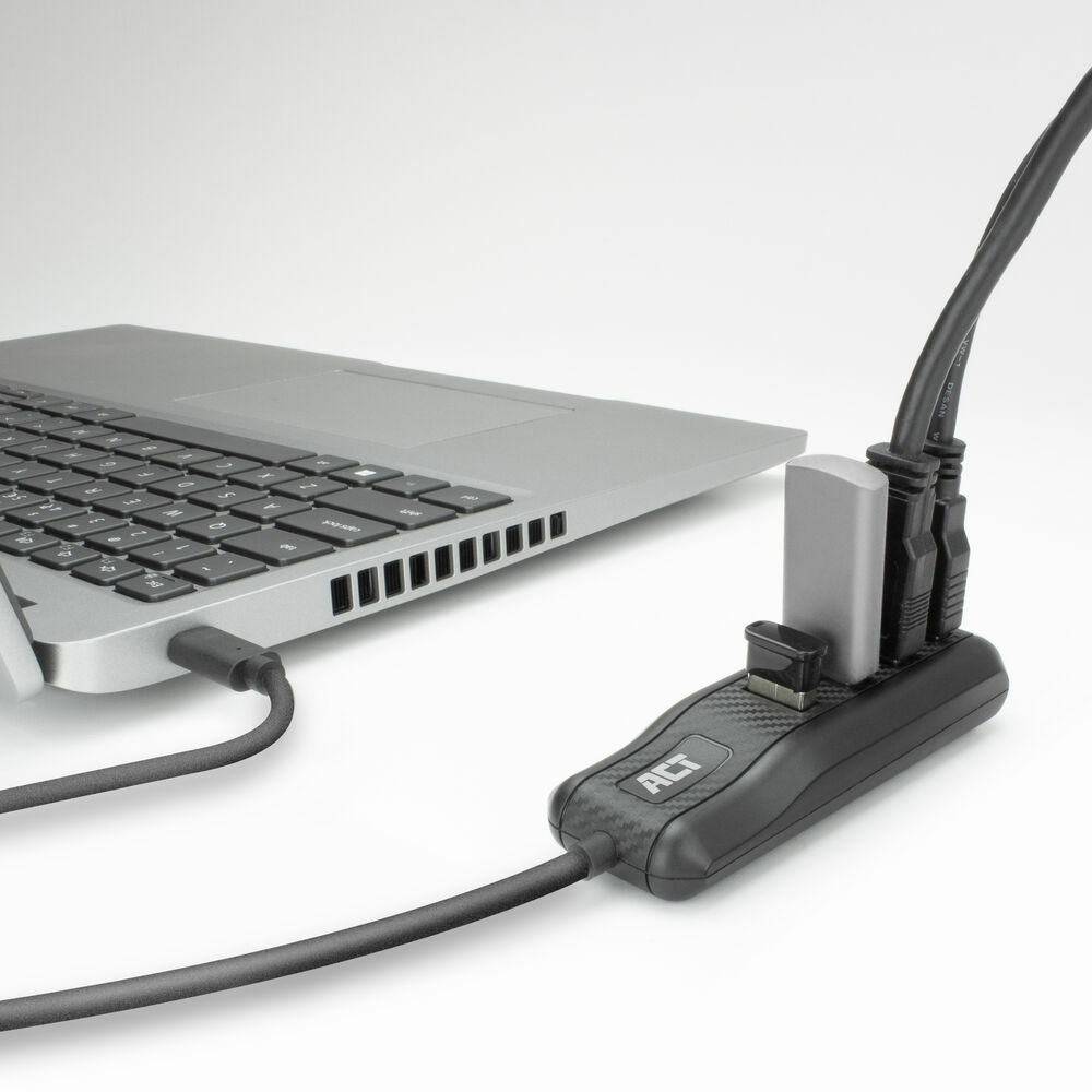 Laptop mit USB-Hub verbunden. Schwarzer Hub mit USB-Anschlüssen und silbernem Adapter. Weißer Hintergrund.