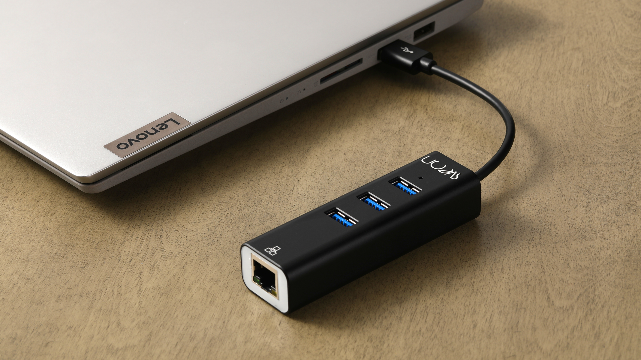 Hub USB nero collegato a un laptop, con porte USB e una porta Ethernet.