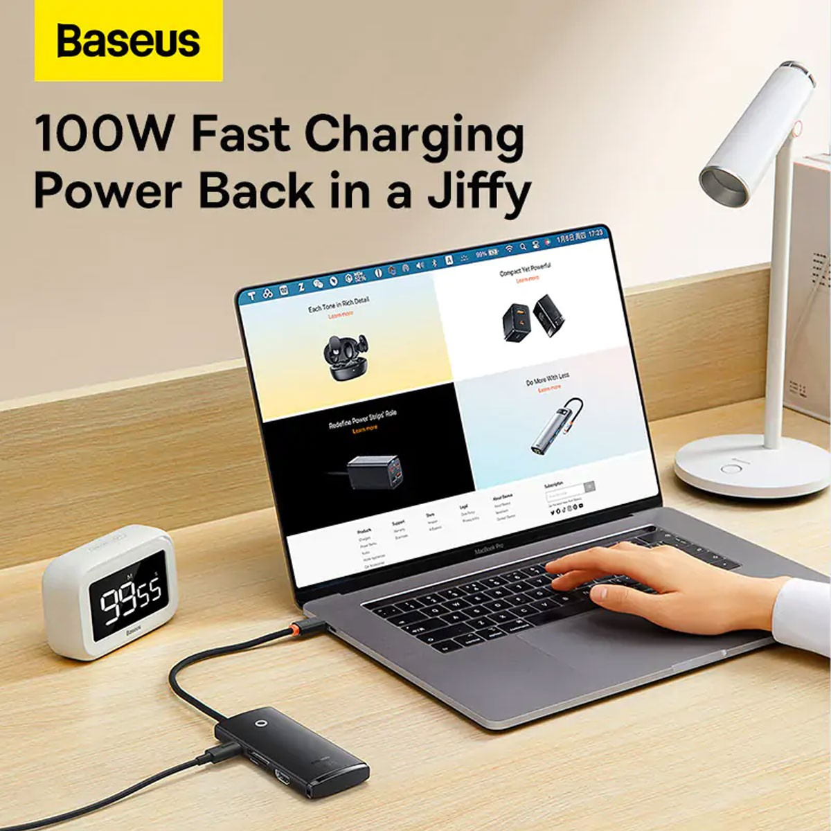 Un laptop su una scrivania con un hub USB, una lampada e un orologio. Il logo Baseus è visibile.