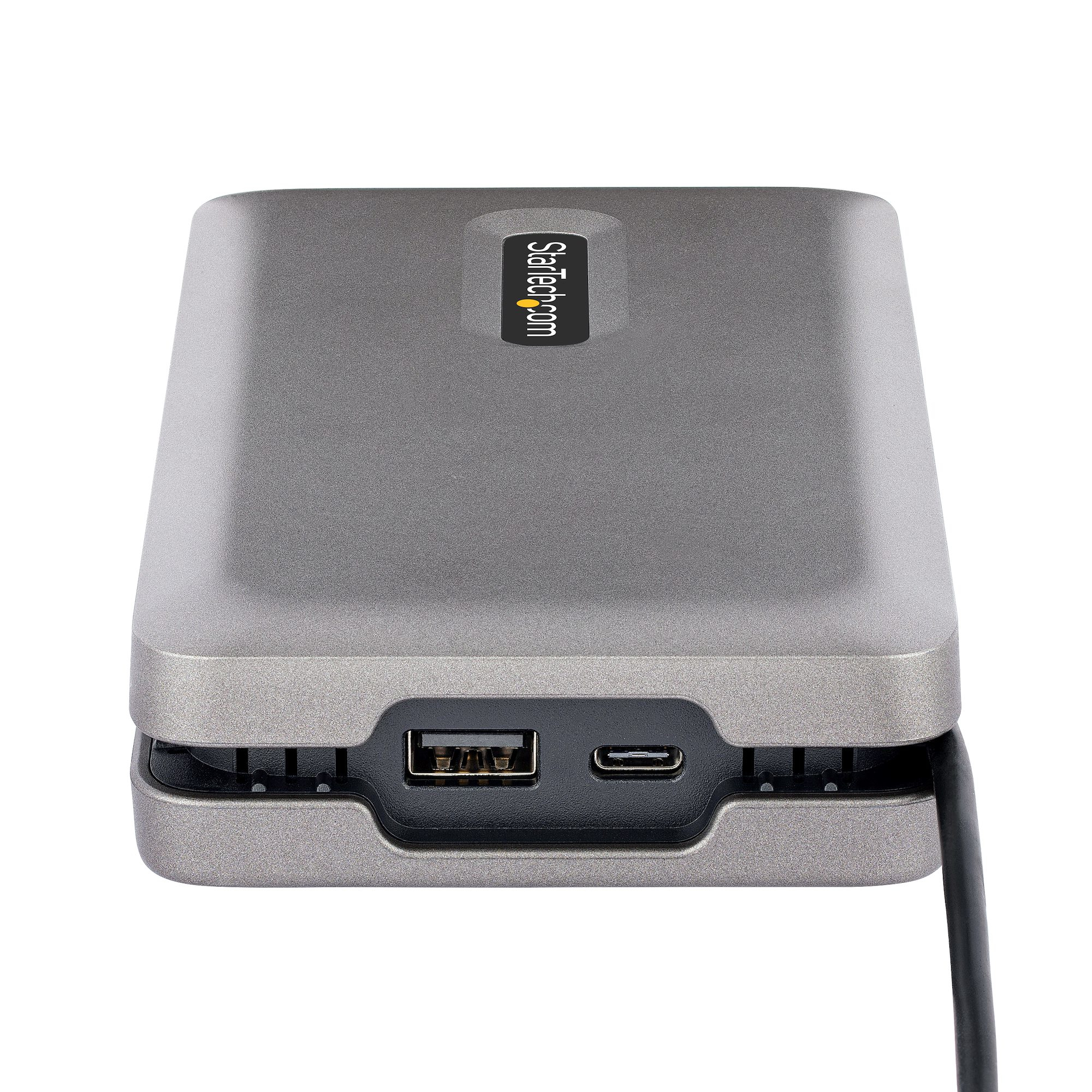 Un disco rigido esterno grigio con porte USB e USB-C. Cavo nero collegato.