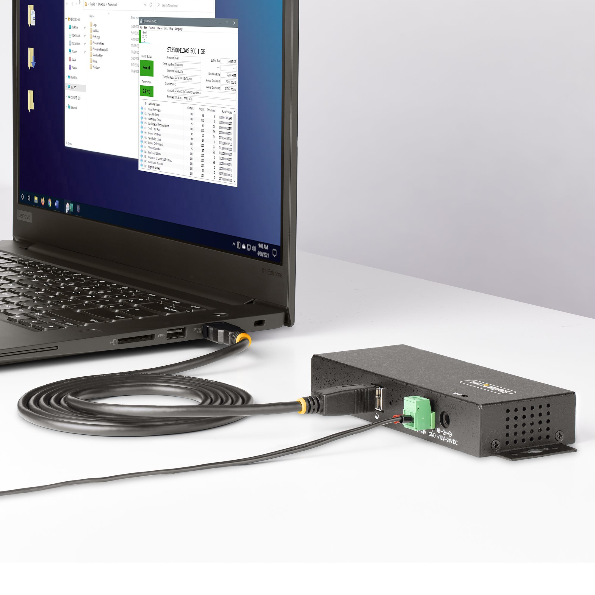 Un laptop collegato a un hub nero. Lo schermo mostra una finestra di gestione file.